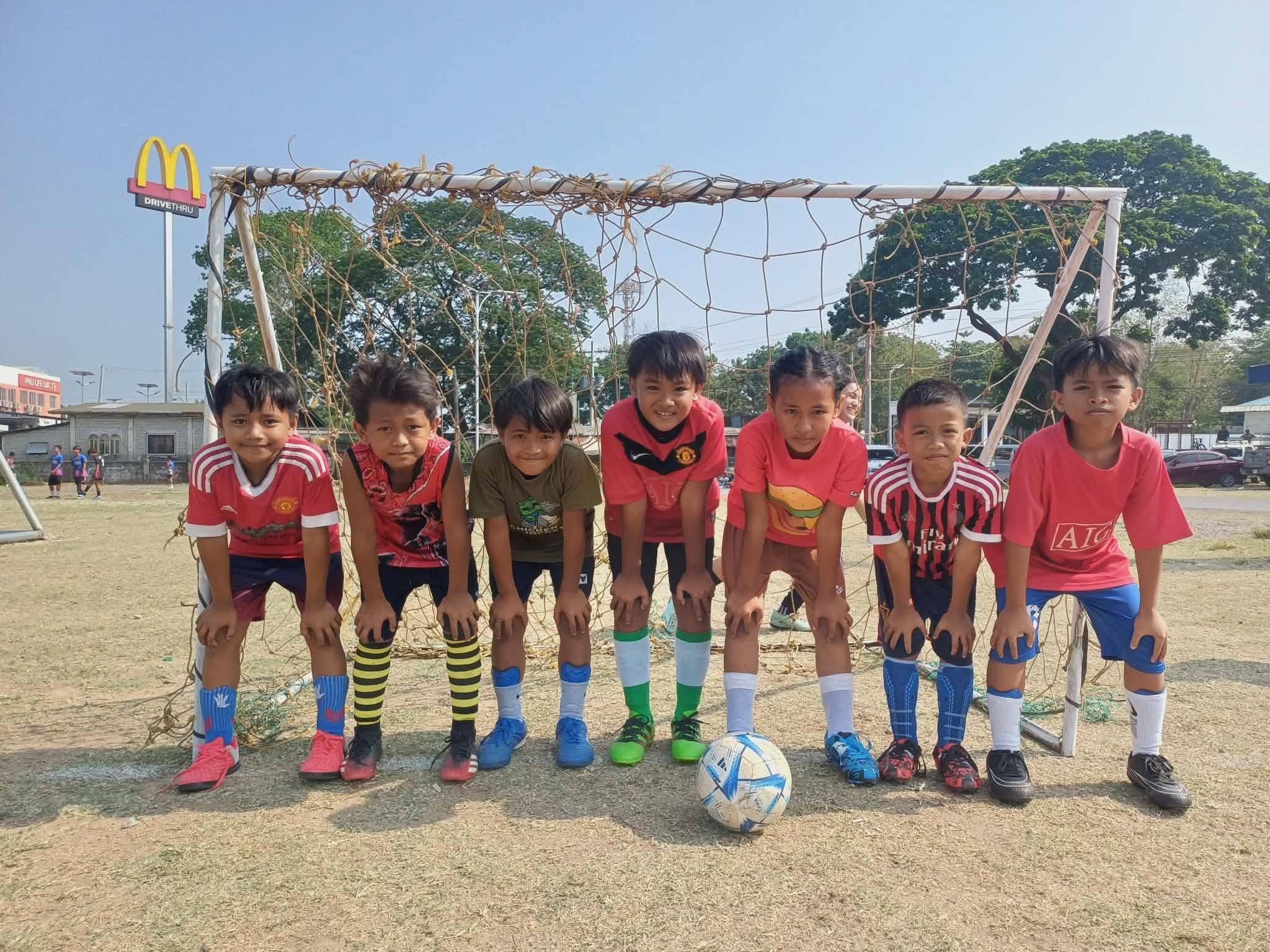 Eight young AFFC players lined up in front of a goal on the Agoo grounds, a ball at their feet